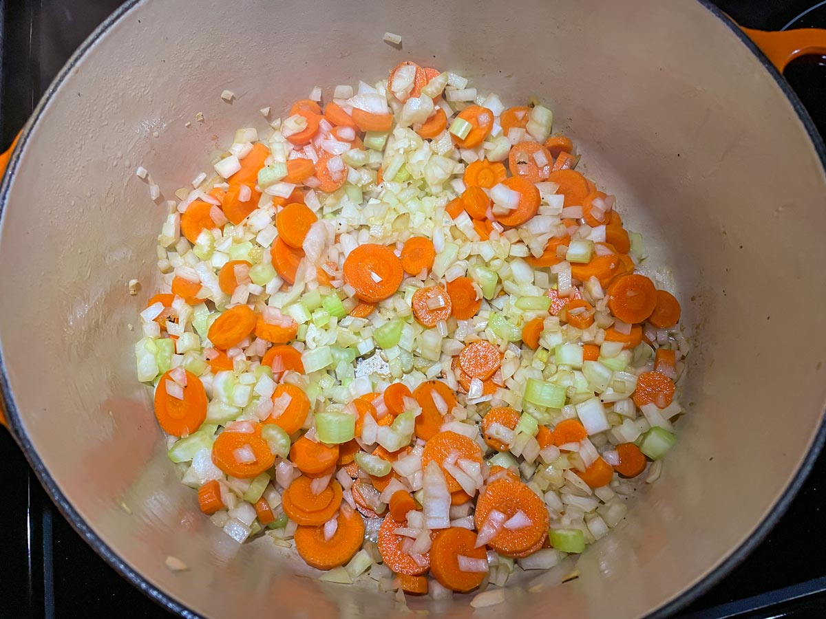 Chopped carrots, onion, and celery in a Dutch oven.