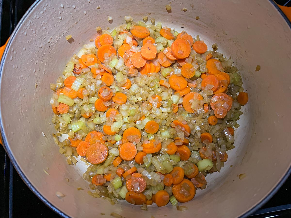 Chopped carrots, onion, and celery softened in a Dutch oven.