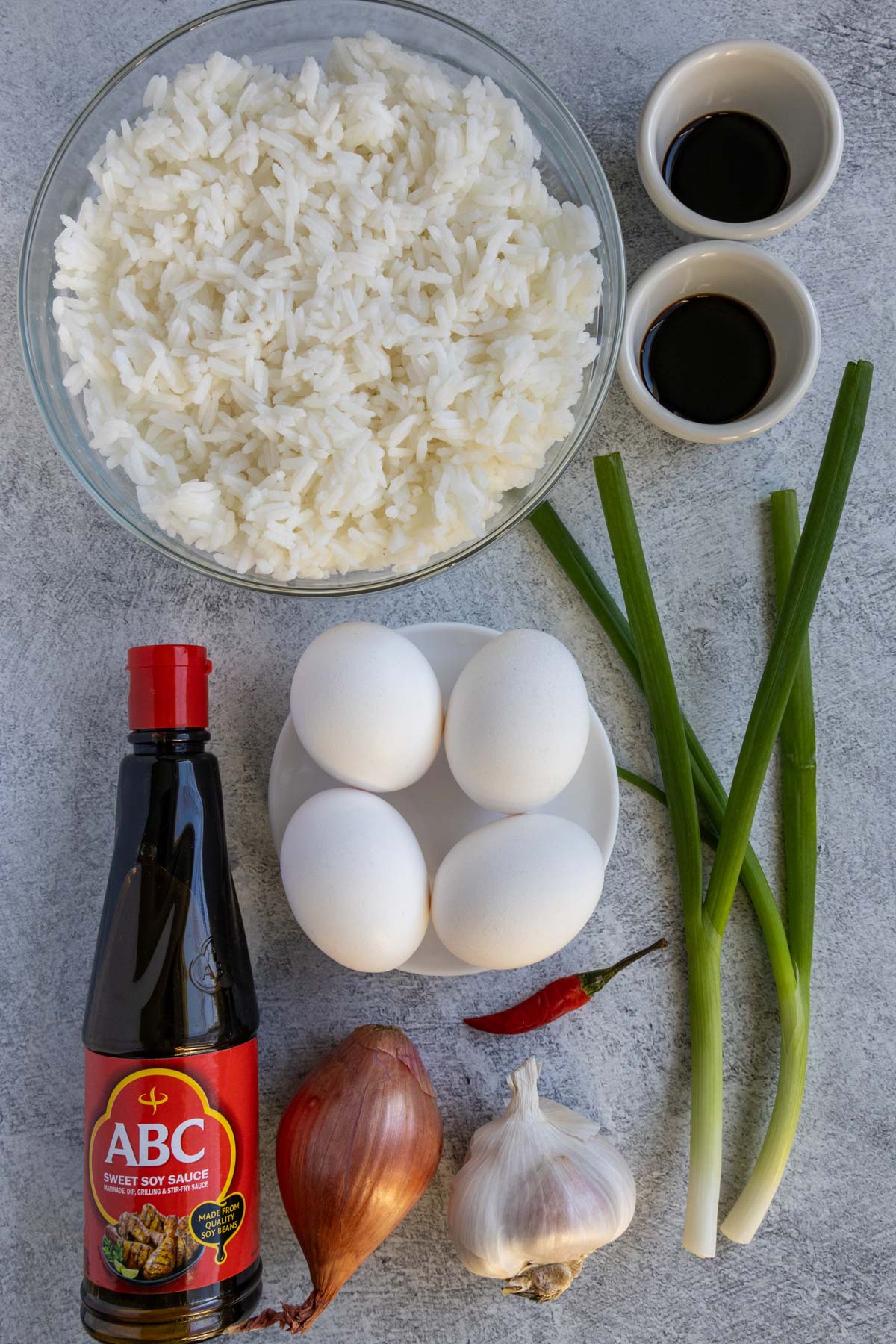 Ingredients for nasi goreng on a light grey background.