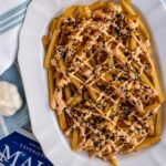 A platter of volcano fries topped with sriracha aioli and furikake.