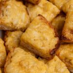 Crabbies with melted cheese and crisp browned edges piled on a platter.