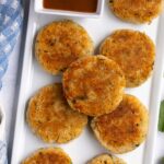 Crispy aloo tikki potato patties on a white rectangular serving dish.