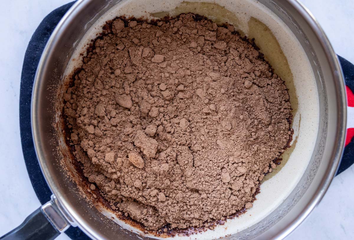 Cocoa powder added to a saucepan.