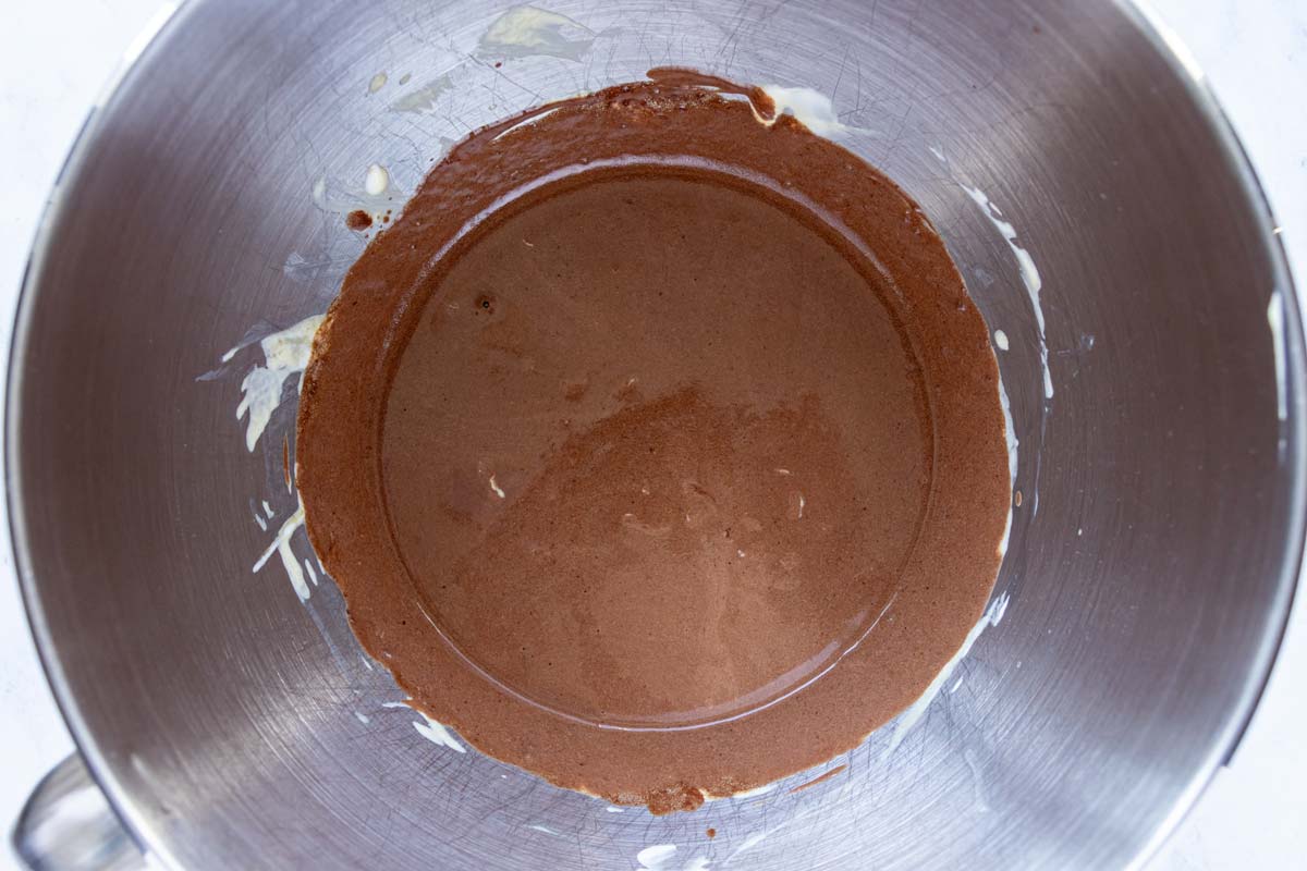 A creamy chocolate mixture in a metal mixing bowl.