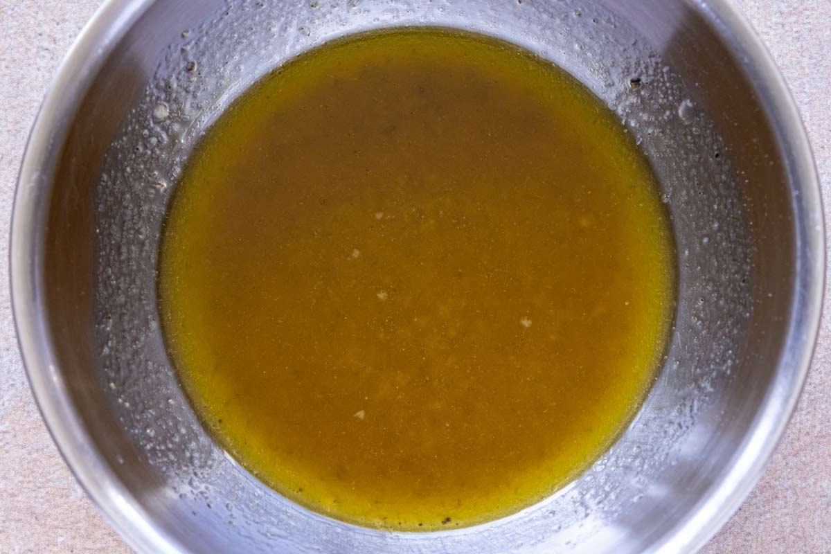 Vinaigrette whisked together in a small metal mixing bowl.