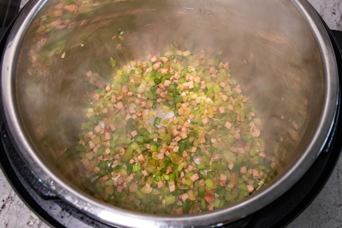 A mixture of diced vegetables and ham cooking in an Instant Pot.