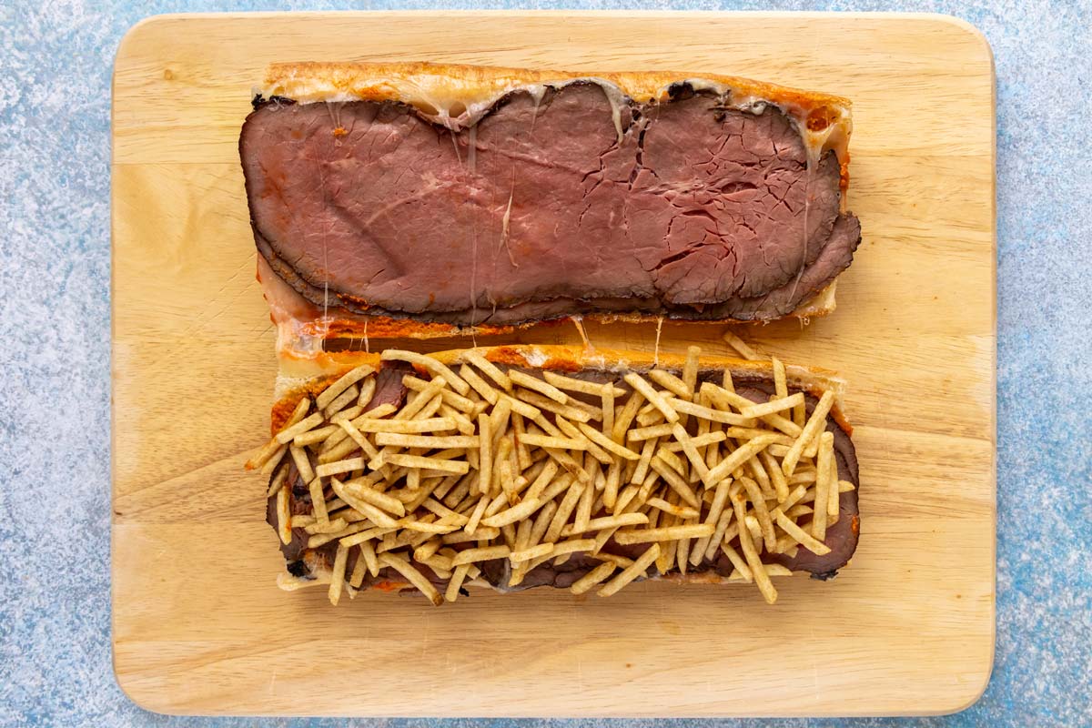 A pan con bistec sandwich opened in the middle to add crispy potato sticks.