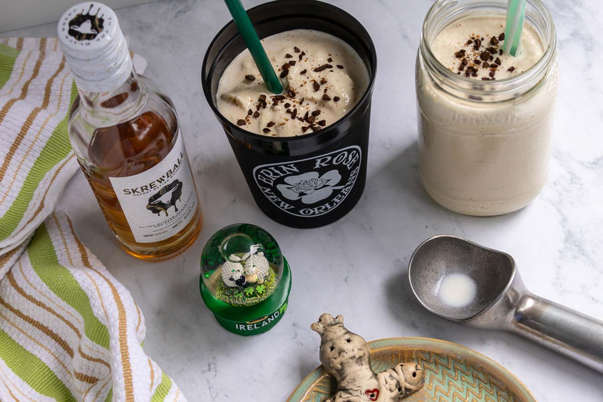 Two cups of frozen Irish coffee next to Irish and New Orleans memorabilia.