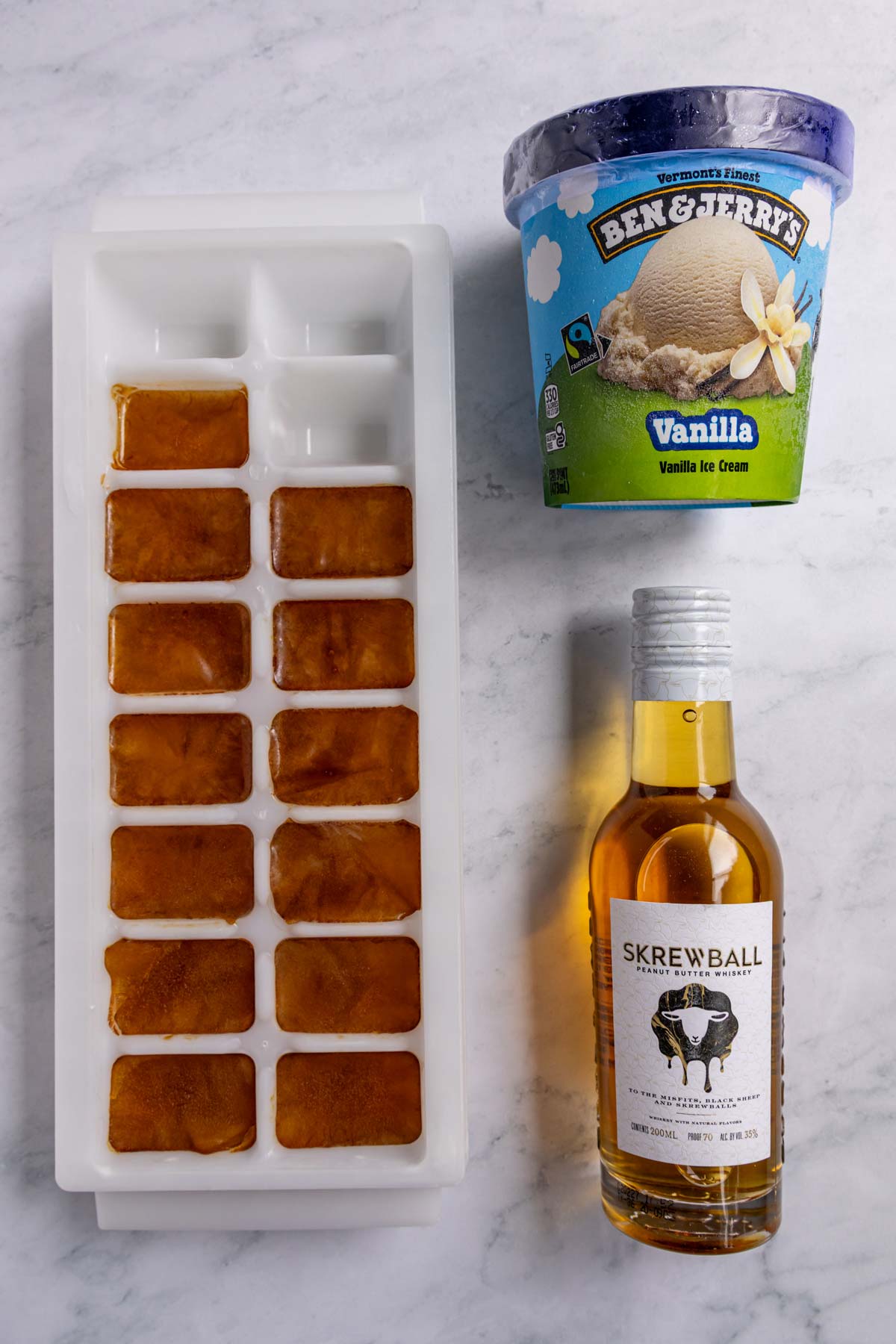Ingredients for frozen Irish coffee on a white marble background.