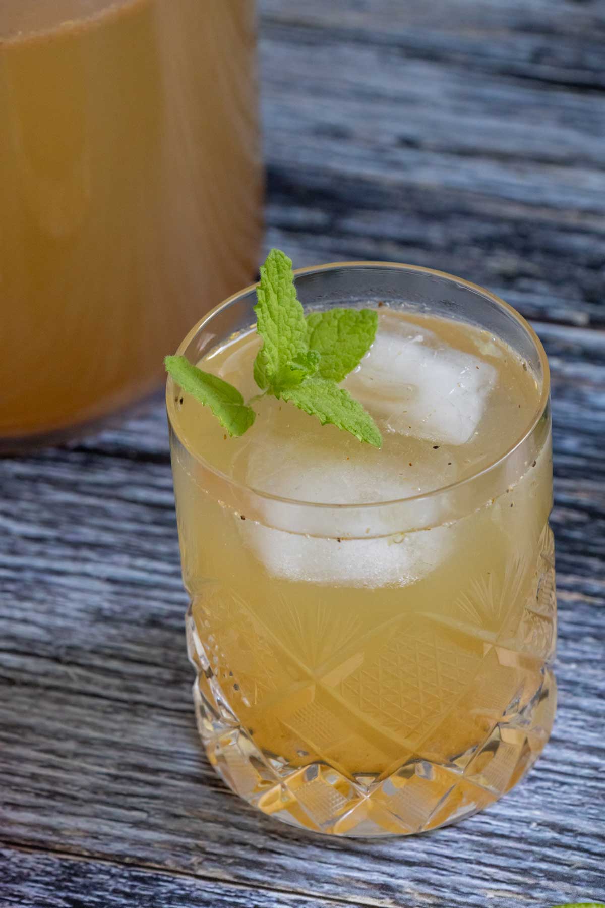 Shikanji / Nimbu Pani served in a short crystal glass with a sprig of mint garnish.