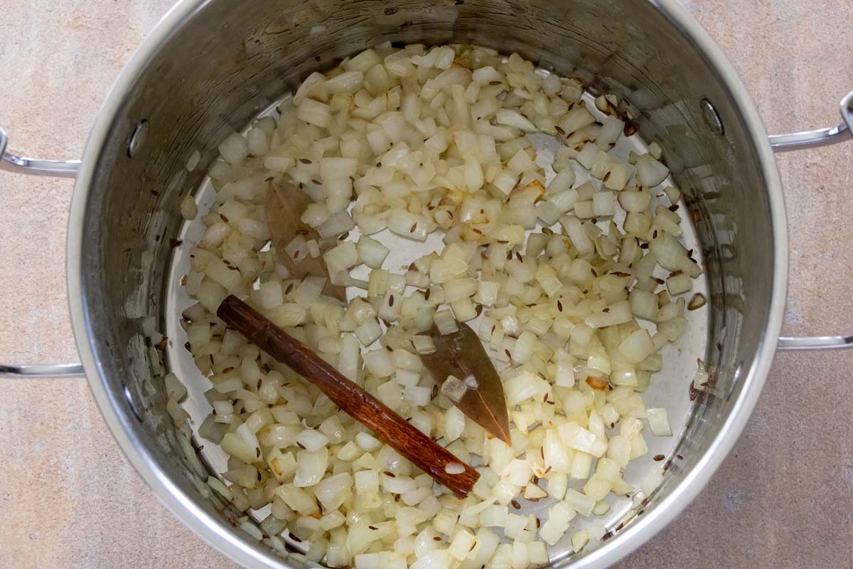 Sauteed chopped onion with cumin seeds, bay leaves, and a cinnamon stick.