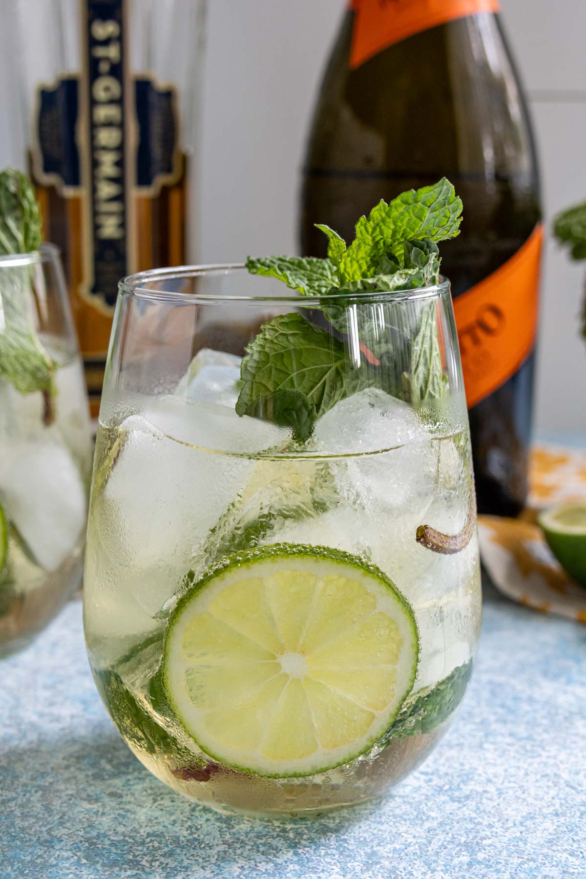 An effervescent Hugo cocktail garnished with a wheel of lime and fresh mint.