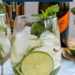 An effervescent Hugo cocktail garnished with a wheel of lime and fresh mint.
