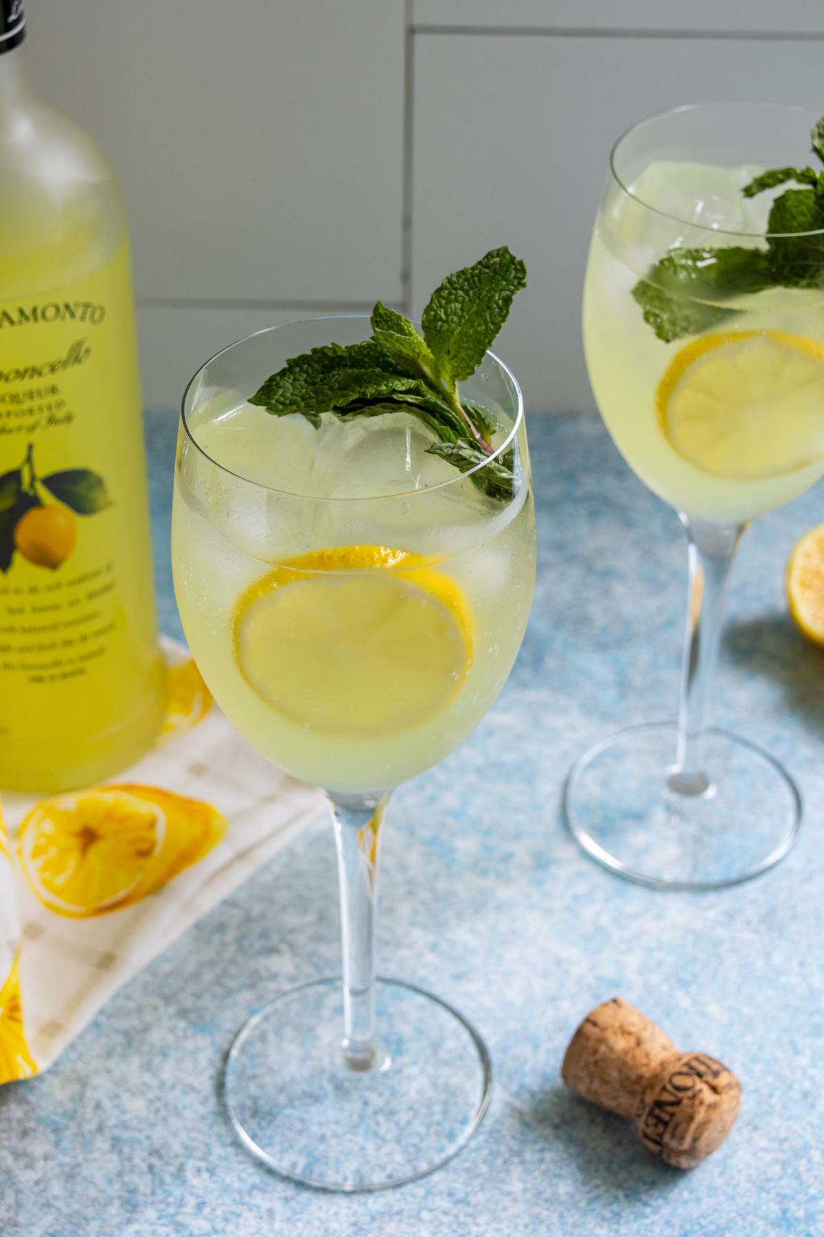 Two glasses of Limoncello Spritz garnished with a lemon slices and fresh mint.