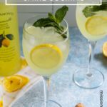 Two glasses of Limoncello Spritz garnished with a lemon slices and fresh mint.