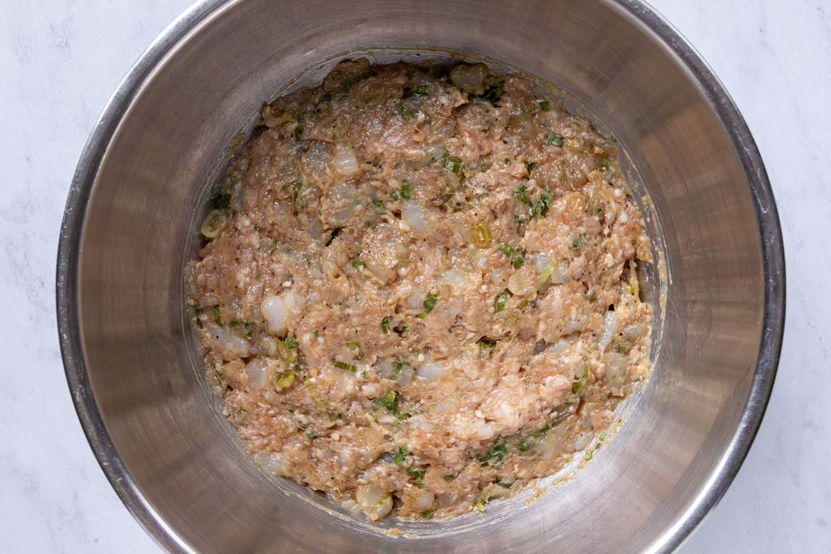 Pork and shrimp dumpling filling ingredients in a bowl after mixing together.