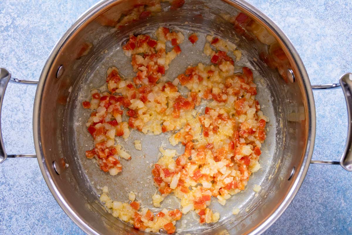 Flour added to a pot of sauteed onion, red pepper, and garlic.
