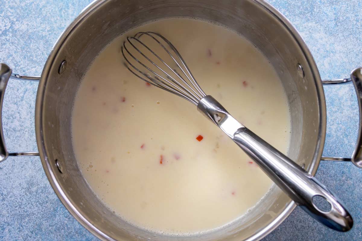 Milk thickened with roux after simmering in a pot with onion and red pepper.