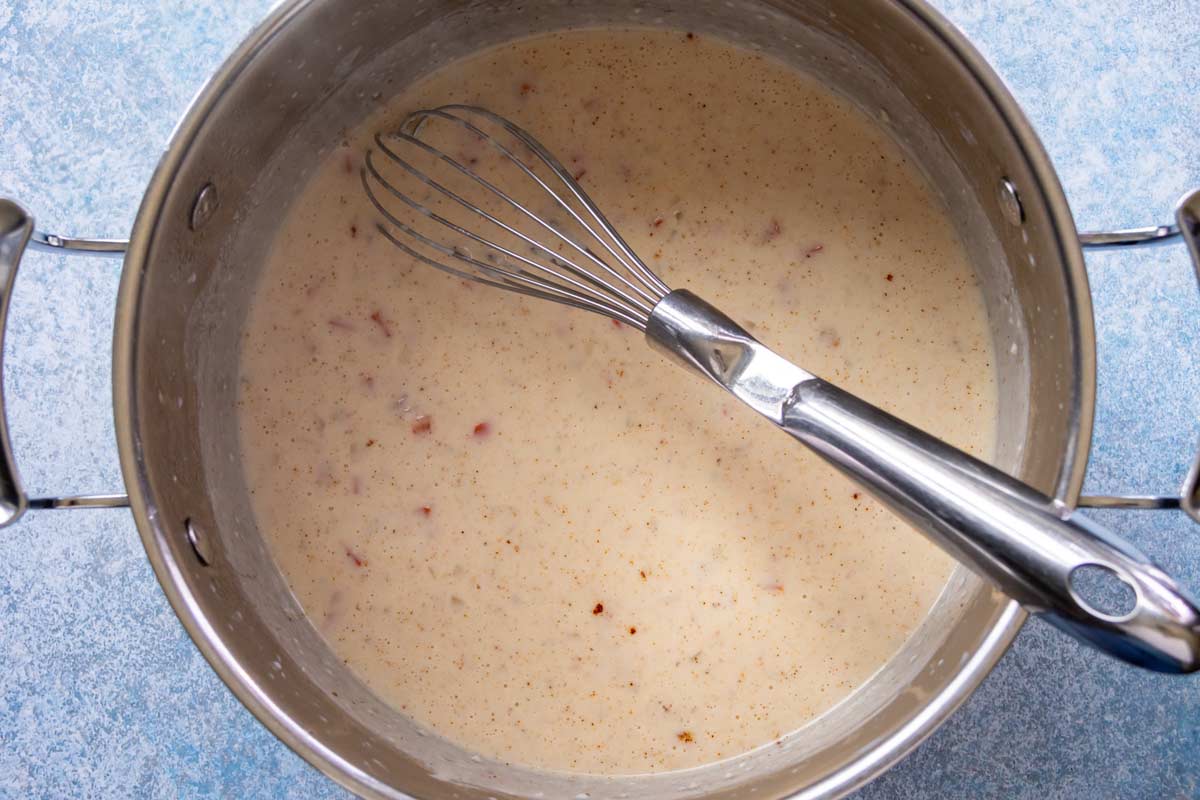 Seasonings whisked into a pot of bechamel to make a base for mac and cheese.