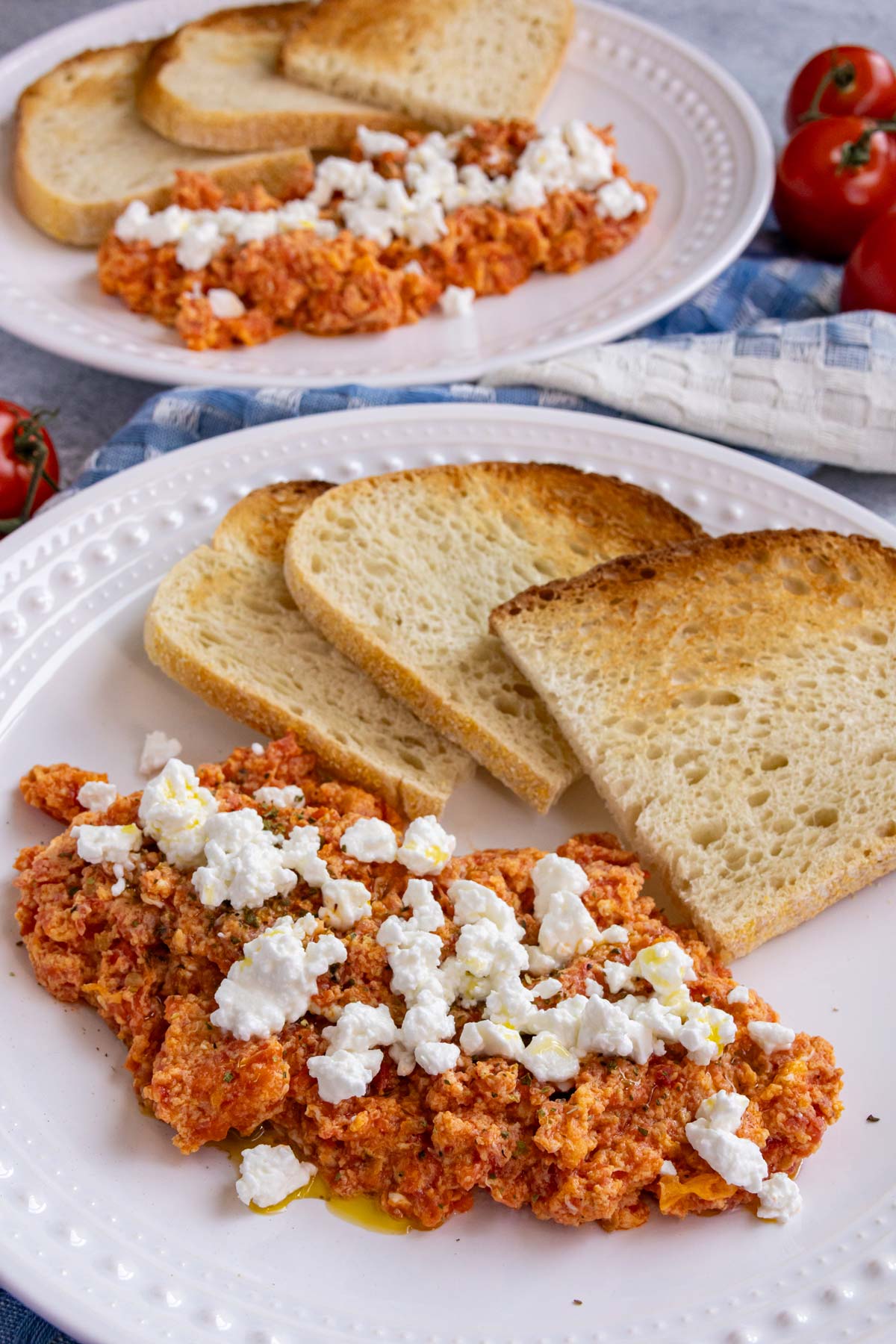 Greek scrambled eggs with tomatoes topped with oregano, crumbled feta, and olive oil.