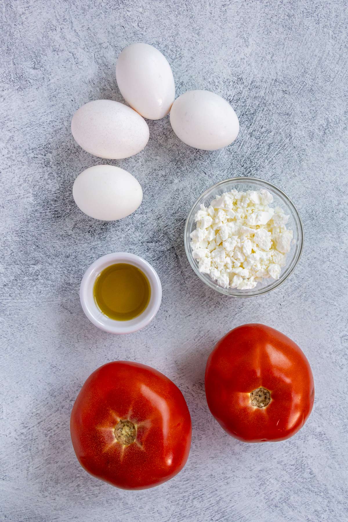 Ingredients for strapatsada on a grey background.