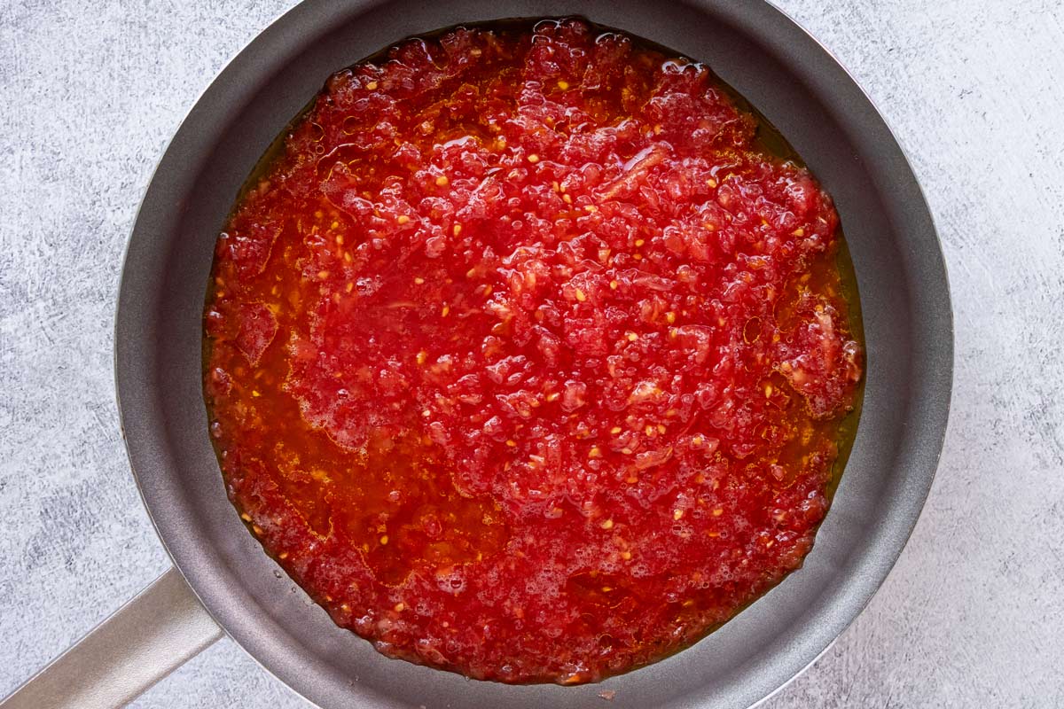 Grated tomato and olive oil in a nonstick skillet.