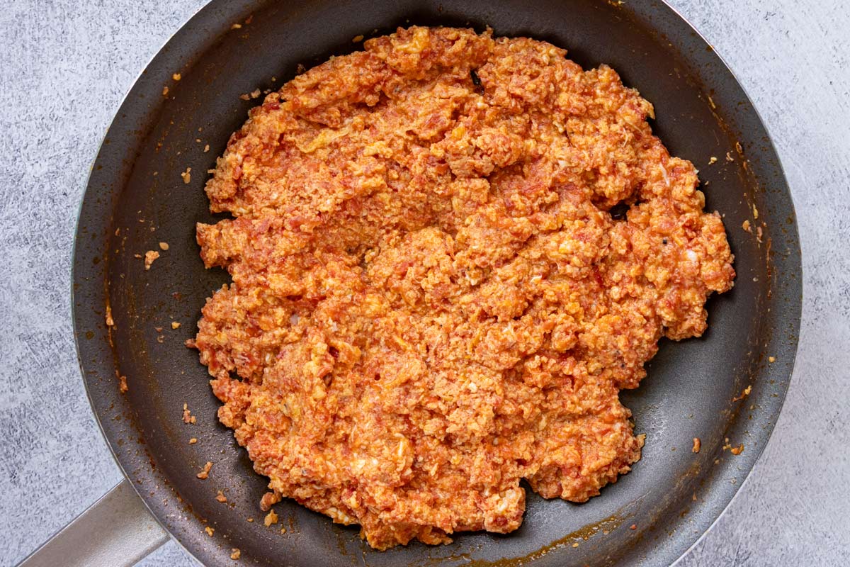 Greek scrambled eggs with tomatoes in a nonstick skillet.