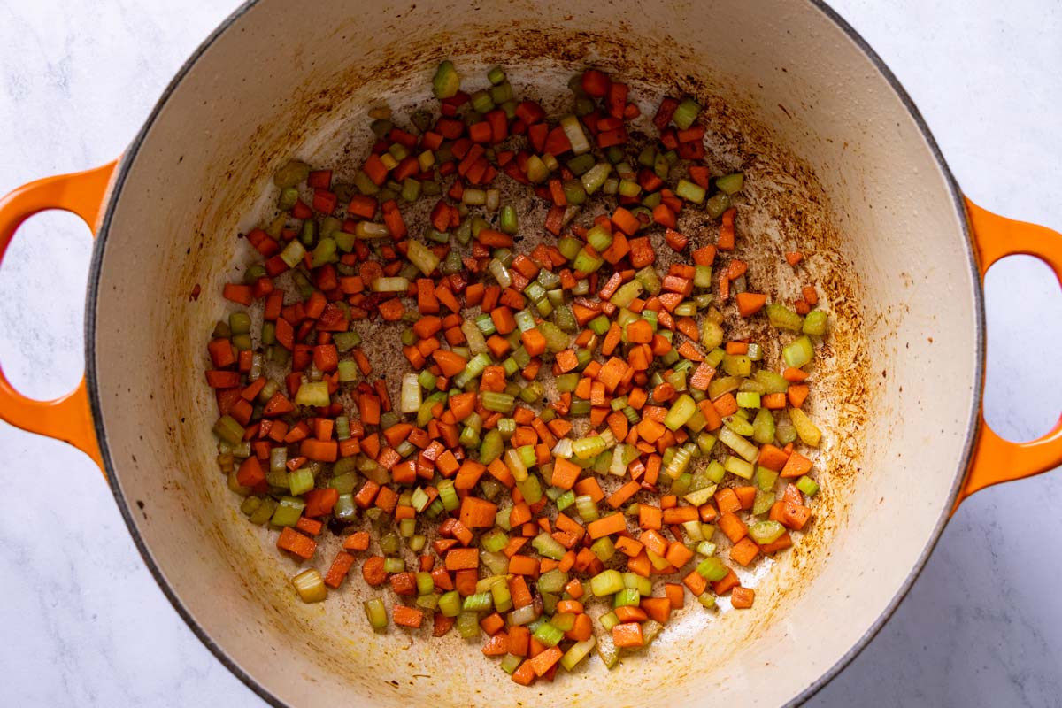 Finely chopped carrots and celery sauteed in a Dutch oven.