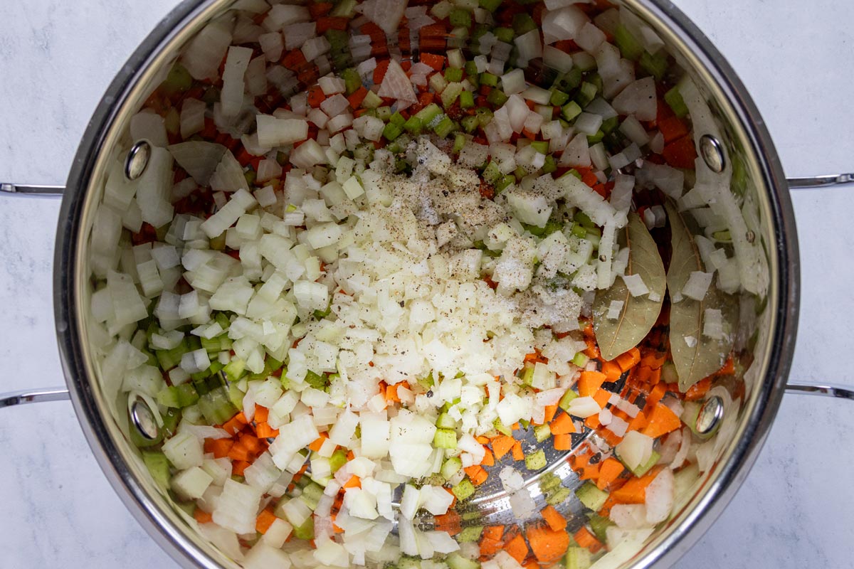 Chopped onion, carrots, celery and seasonings in a large soup pot.