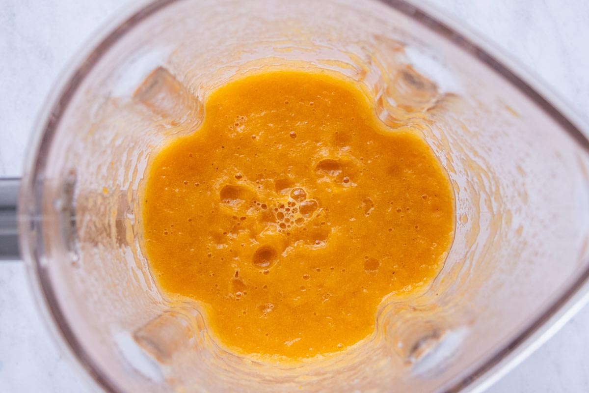 Pureed vegetables and broth in the jar of a blender.
