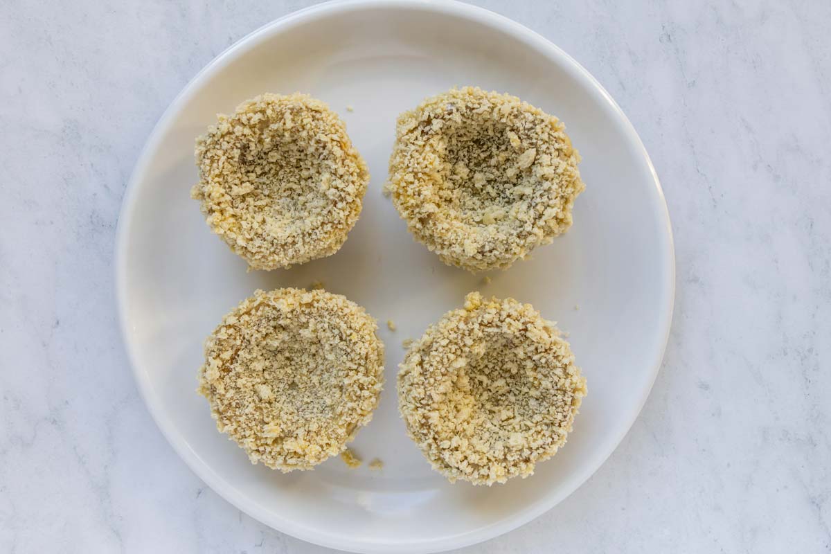Artichoke bottoms breaded with panko on a white plate.