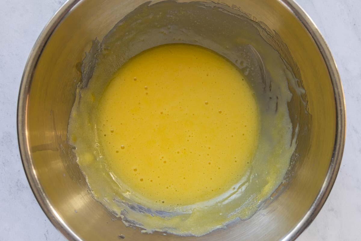 Hollandaise sauce in a metal mixing bowl.