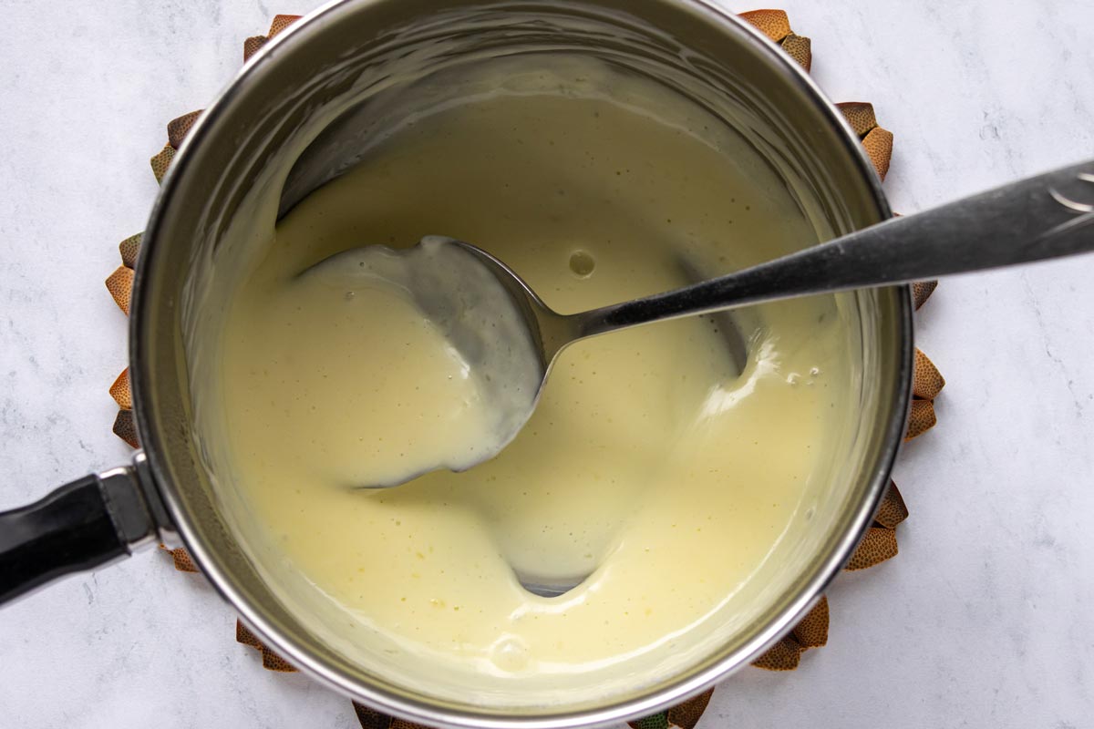 Thickened heavy cream in a saucepan.