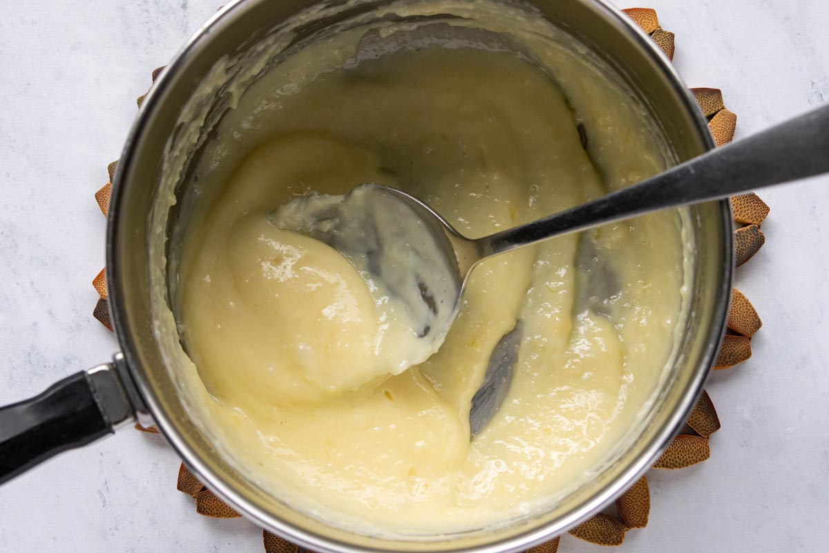 Parmesan cheese and crushed garlic stirred into a saucepan of thickened heavy cream.