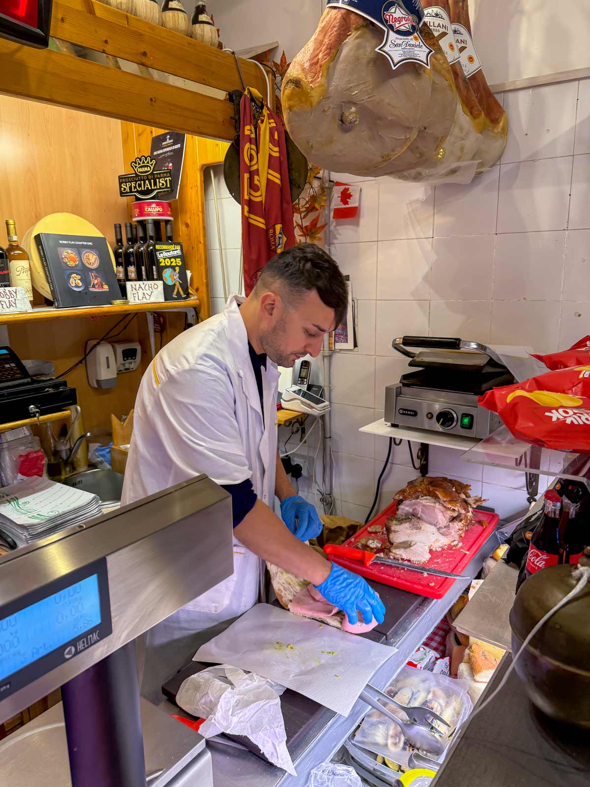 Claudio assembling a mordadella sandwich inside La Vita e un Mozzico in Rome.