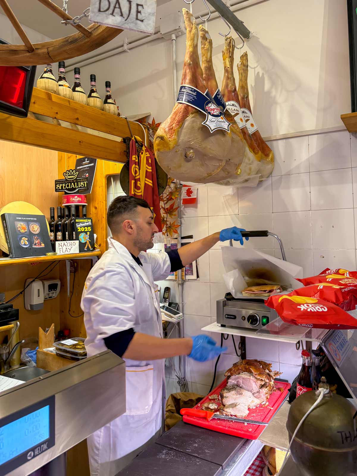 Claudio pressing a sandwich in a sandwich press inside La Vita e un Mozzico in Rome.