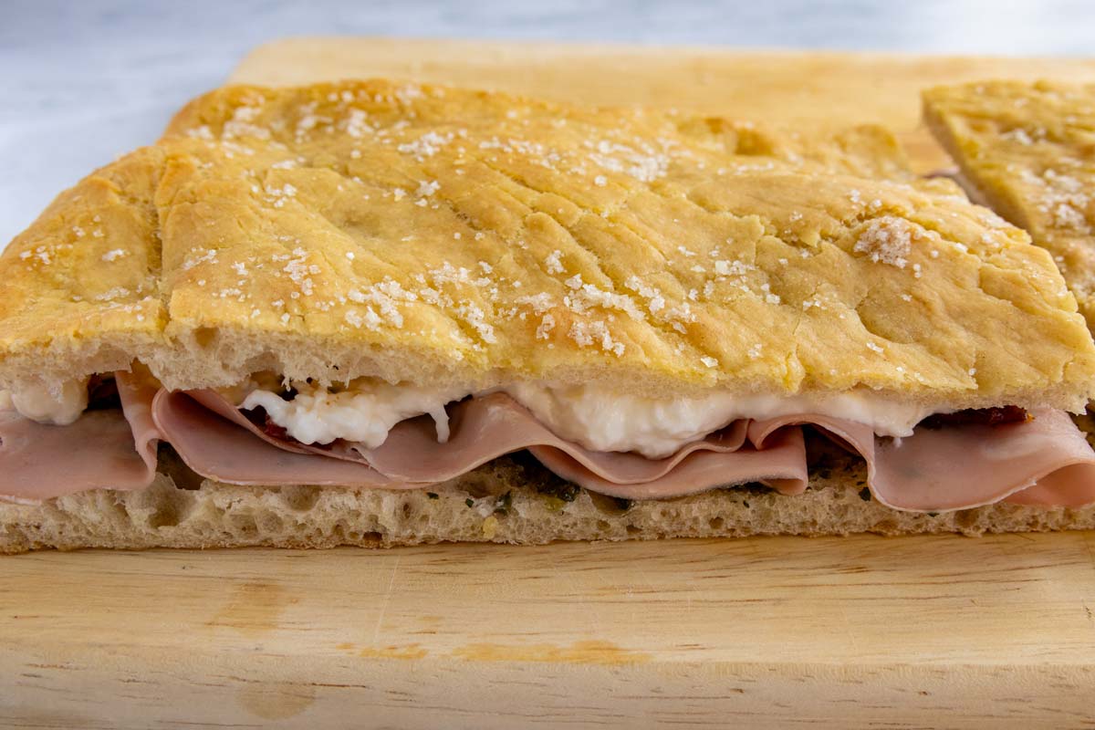 A mortadella and stracciatella cheese sandwich on pizza bianca.