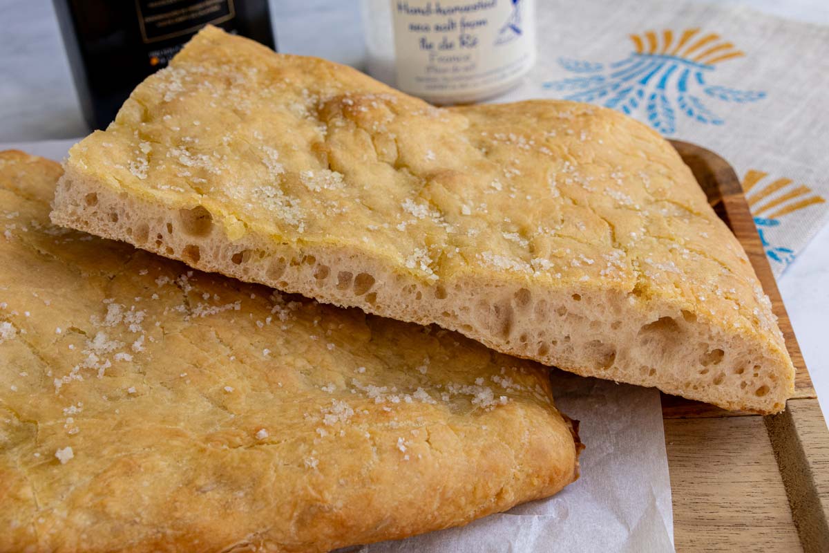 Cross-section of a piece of pizza bianca showing off its large airy holes and crisp golden crust.