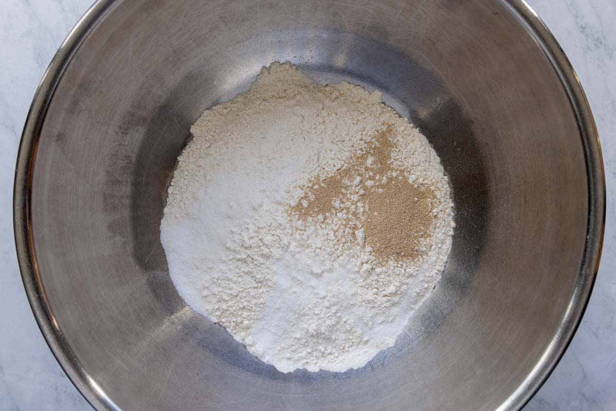 Flour, salt, and instant yeast in a metal mixing bowl.
