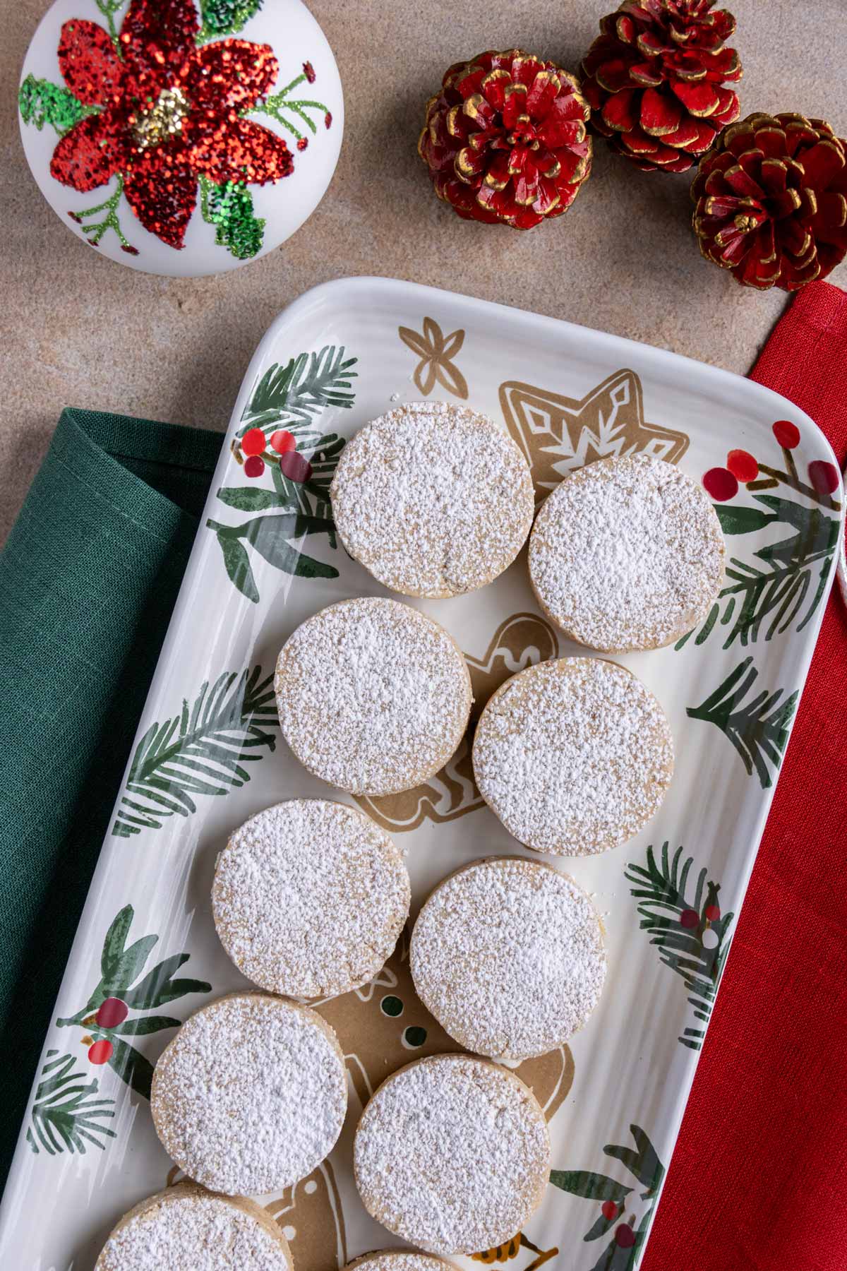 Spanish polvorones shortbread cookies on a holiday platter with red and green linens on either side.