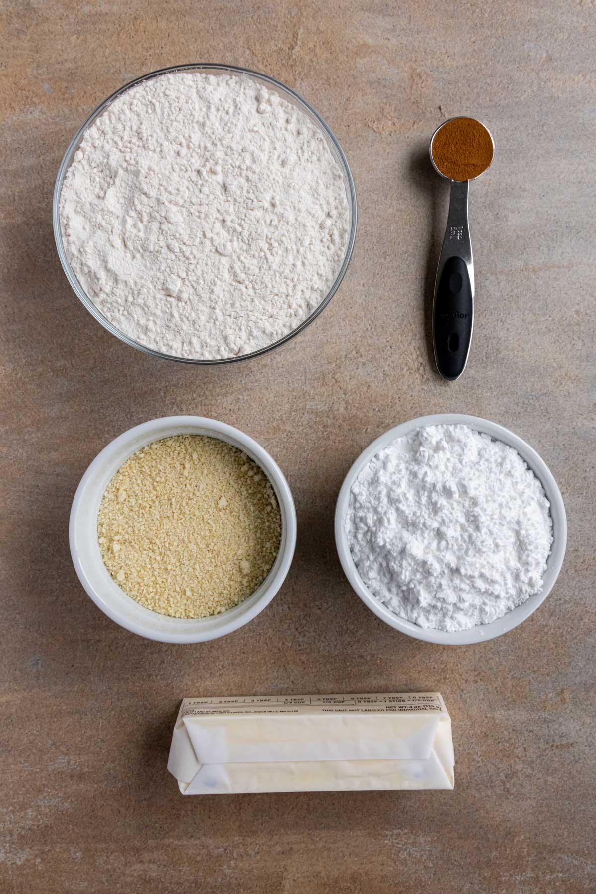 Ingredients for Spanish polvorones shortbread cookies on a beige background.