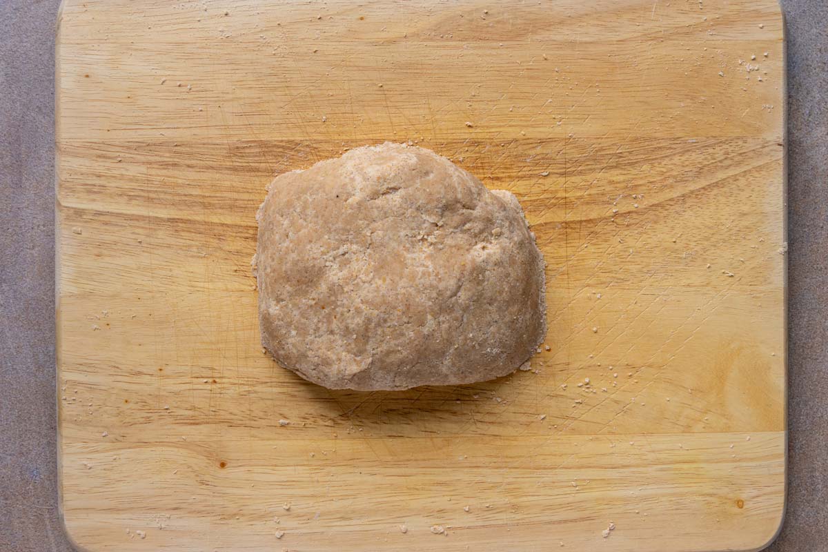 Dough that has been pressed into a firm oval shape before patting it out flat.