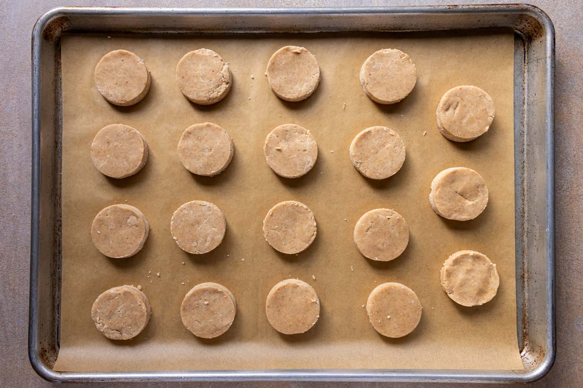 Rounds of dough arranged on a parchment paper-lined baking sheet.