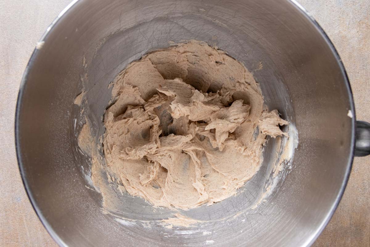 Butter, powdered sugar, and ground cinnamon beaten together in a mixing bowl.