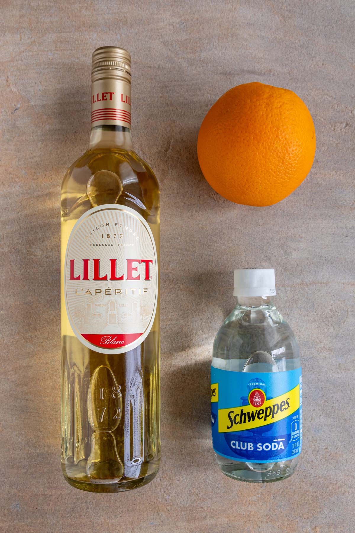 Ingredients for Lillet Spritz on a beige background.