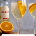 A glass of Lillet Spritz garnished with a half slice of orange.
