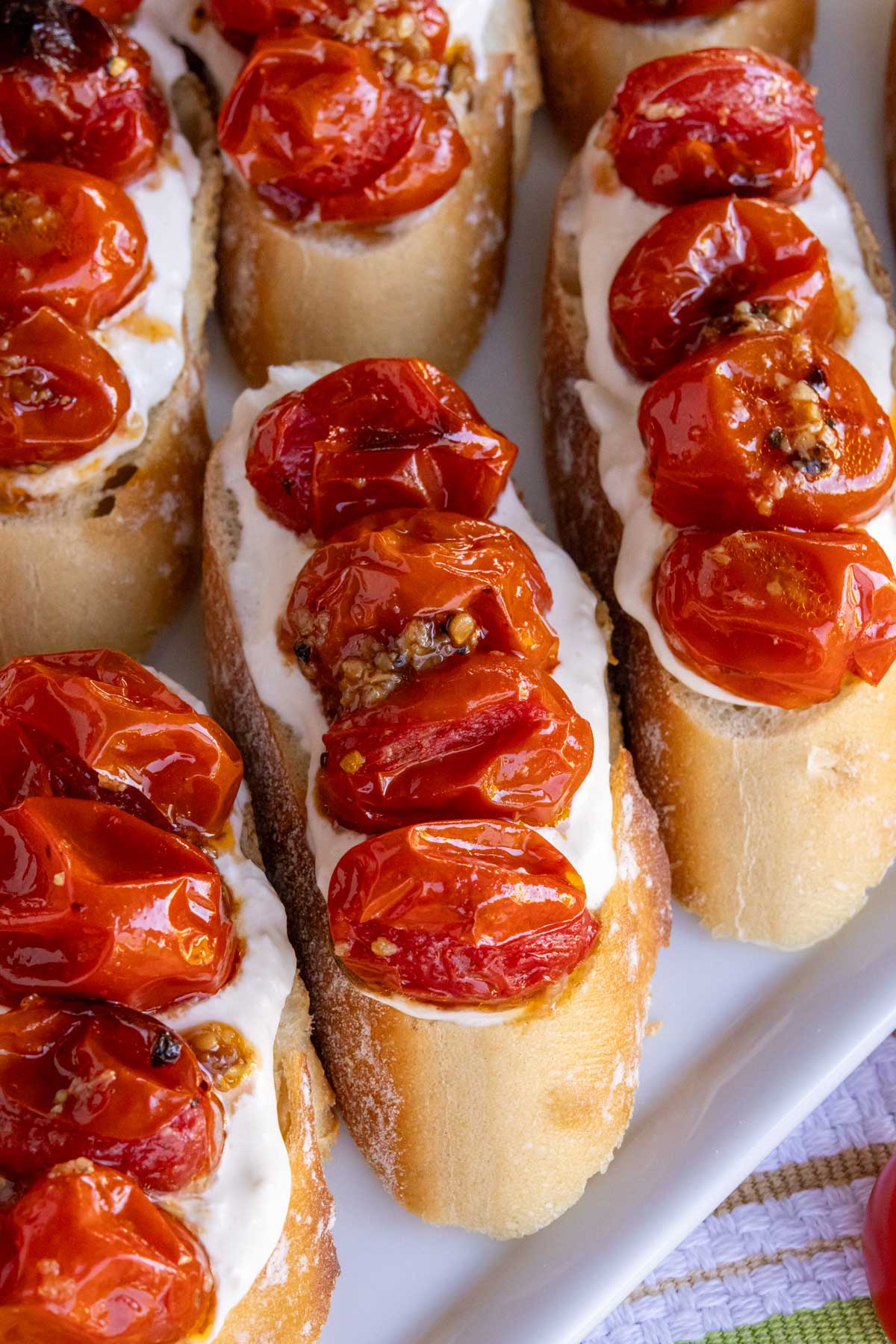 Toasted slices of baguette topped with soft stracciatella cheese and garlic-roasted cherry tomatoes.