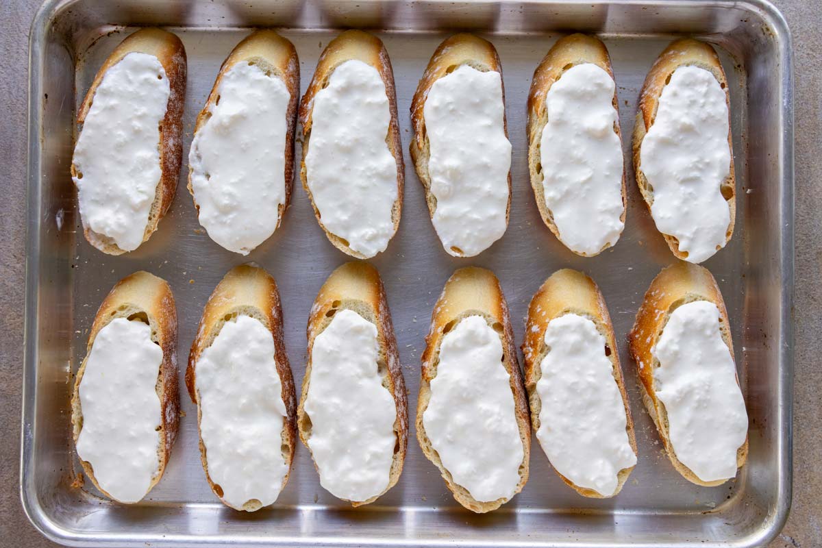 Lightly toasted slices of baguette topped with soft stracciatella cheese.