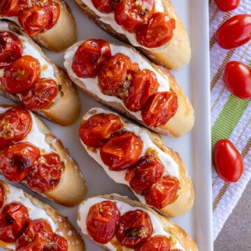 Bruschetta topped with soft stracciatella cheese and garlic-roasted cherry tomatoes.