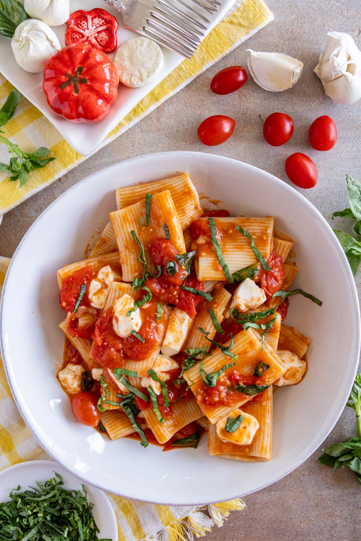 Pasta alla sorrentina garnished with basil chiffonade served in a wide pasta bowl.